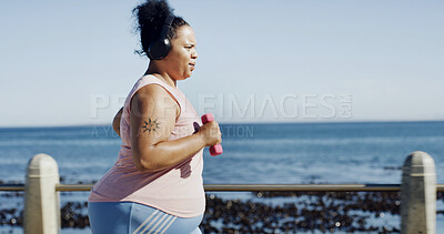 Buy stock photo Fitness, headphones and woman by beach with music, podcast or running for exercise. Space, audio and plus size person to lose weight with radio, cardio and workout or training outdoor by promenade