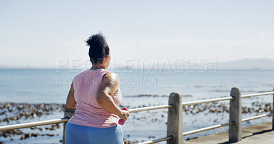 Buy stock photo Running, dumbbell and back of plus size woman at beach for workout, cardio challenge and health. Weight loss, exercise and wellness with person on promenade for training, space and fitness