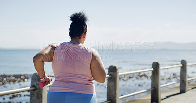 Buy stock photo Running, dumbbell and fitness with plus size woman at beach for workout, cardio challenge and health. Weight loss, exercise and wellness with back of person on promenade for training and space