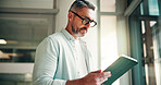 Tablet, reading and businessman in office with research for finance report with budget plan. Digital technology, professional and mature male financial manager with ideas for investment proposal.