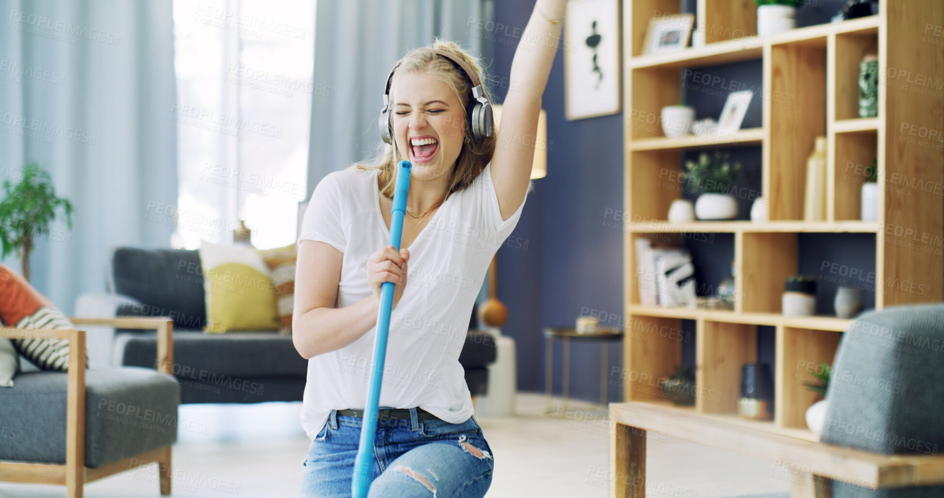 Buy stock photo Woman, broom and singing with headphones in home, cleaning and happy with streaming in living room. Girl, excited and listen to music with audio subscription, performance or dance for chores at house