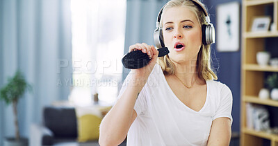 Buy stock photo Singing, hair brush and headphones with woman in home for karaoke, streaming and soundtrack. Music, relax and radio subscription with person in living room of apartment for audio and connection