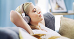 Eyes closed, headphones and relax with woman on sofa for streaming service, guided meditation and white noise. Zen radio, subscription and mindfulness with person in living room of home for wellness