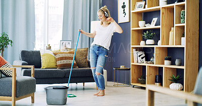 Buy stock photo Girl, cleaning and singing with headphones in home, broom and happy with streaming in living room. Woman, excited and listen to music with audio subscription, karaoke or voice for chores at house