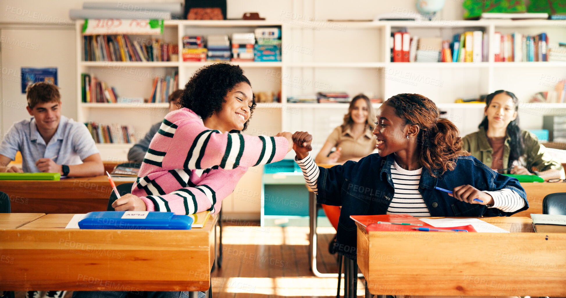 Buy stock photo Fist bump, education and girls in classroom for college admission tests, smile and quiz. Aptitude assessment, celebration and academy with students in high school for lesson or scholarship exam