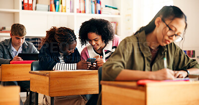 Buy stock photo Education, smile and girls in classroom, cellphone and conversation with social media. Students, teenager and friends with discussion, high school or smartphone with knowledge, app or online chatting