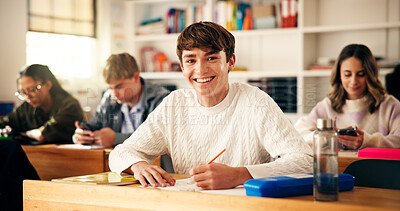 Buy stock photo Smile, writing and portrait of teenager in classroom for learning, education or development. Happy, books and face of boy with studying at high school for test, exam or assignment on campus.