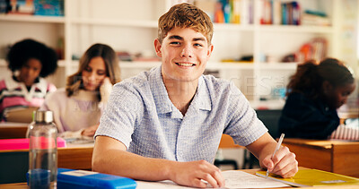 Buy stock photo Happy, writing and portrait of boy teenager in classroom for learning, education or development. Smile, student and male person with books for study at school for test, exam or assignment on campus.