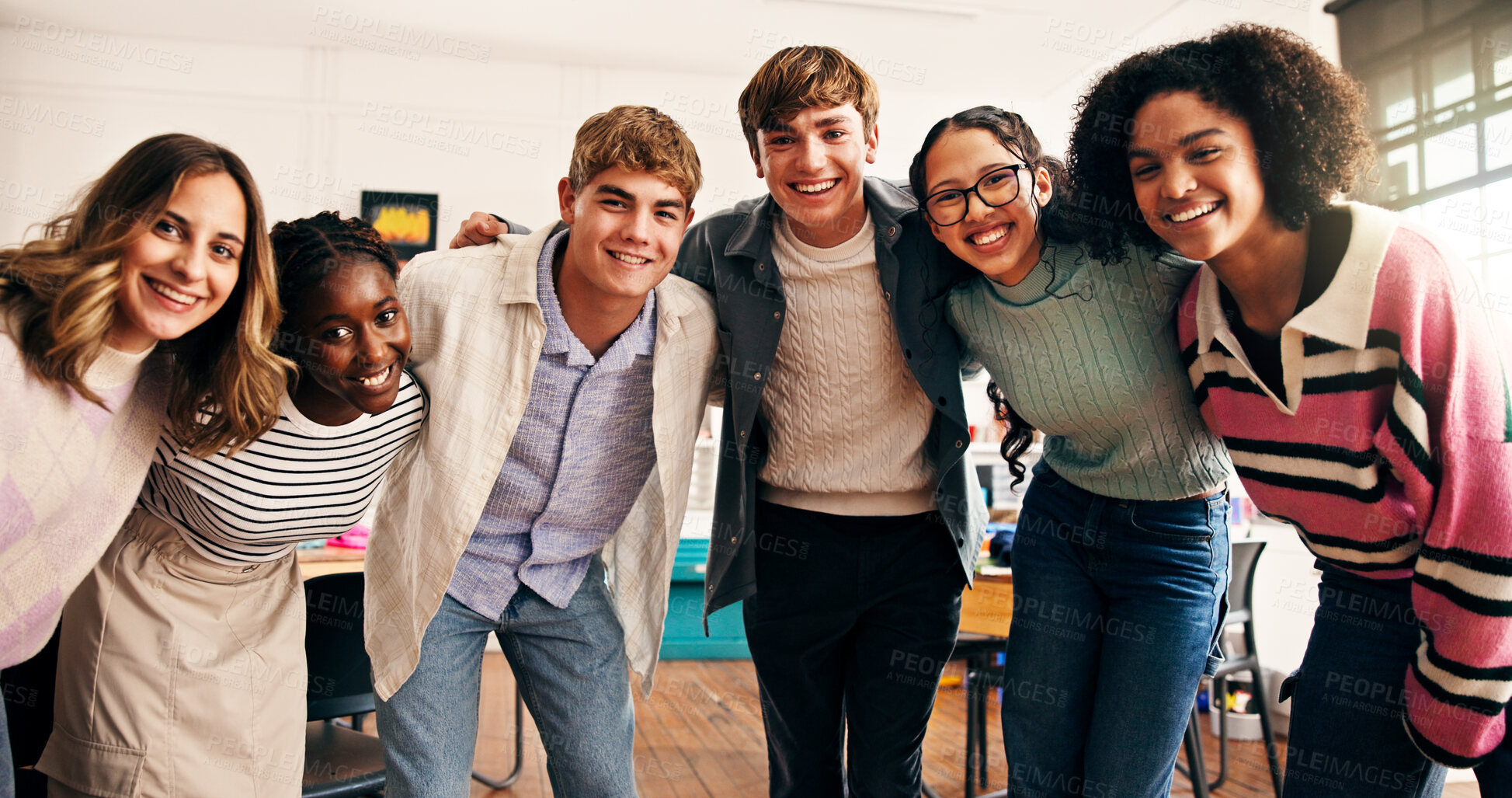 Buy stock photo Portrait, high school students and group hug for support, academic development and learning together. Teenager, boys and girls embrace in classroom with smile, happiness and education with friends