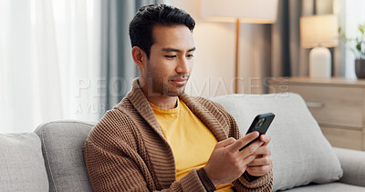 Buy stock photo Phone, relax and scrolling with man on sofa in living room of home for social media browsing. App, communication and reading with person typing in apartment for internet search or text message