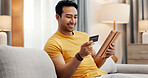Online shopping, credit card and happy man on tablet in home for purchase, payment and subscription. Sofa, relax and person with debit info on tech for ecommerce, website sale and internet banking