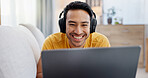 Man, laptop and headphones on sofa for social media, movie and video streaming or website in home. Smile, internet audio and happy person on couch with technology, break and watching film on app