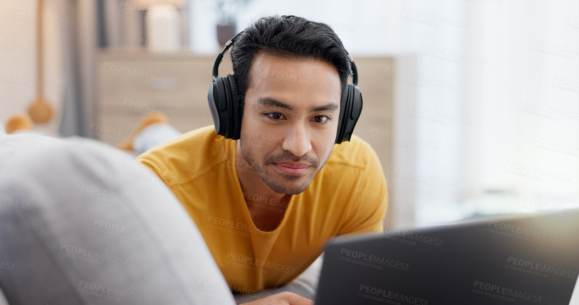 Buy stock photo Headphones, laptop and relax with man on sofa in living room of home for online subscription. Computer, streaming and watching video with person in apartment for break, entertainment or media