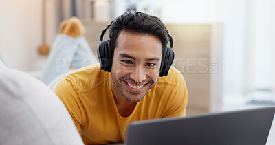 Buy stock photo Man, laptop and headphones on sofa for streaming, movie and social media video or website in home. Smile, internet audio and happy person on couch with technology, break and watching film on app