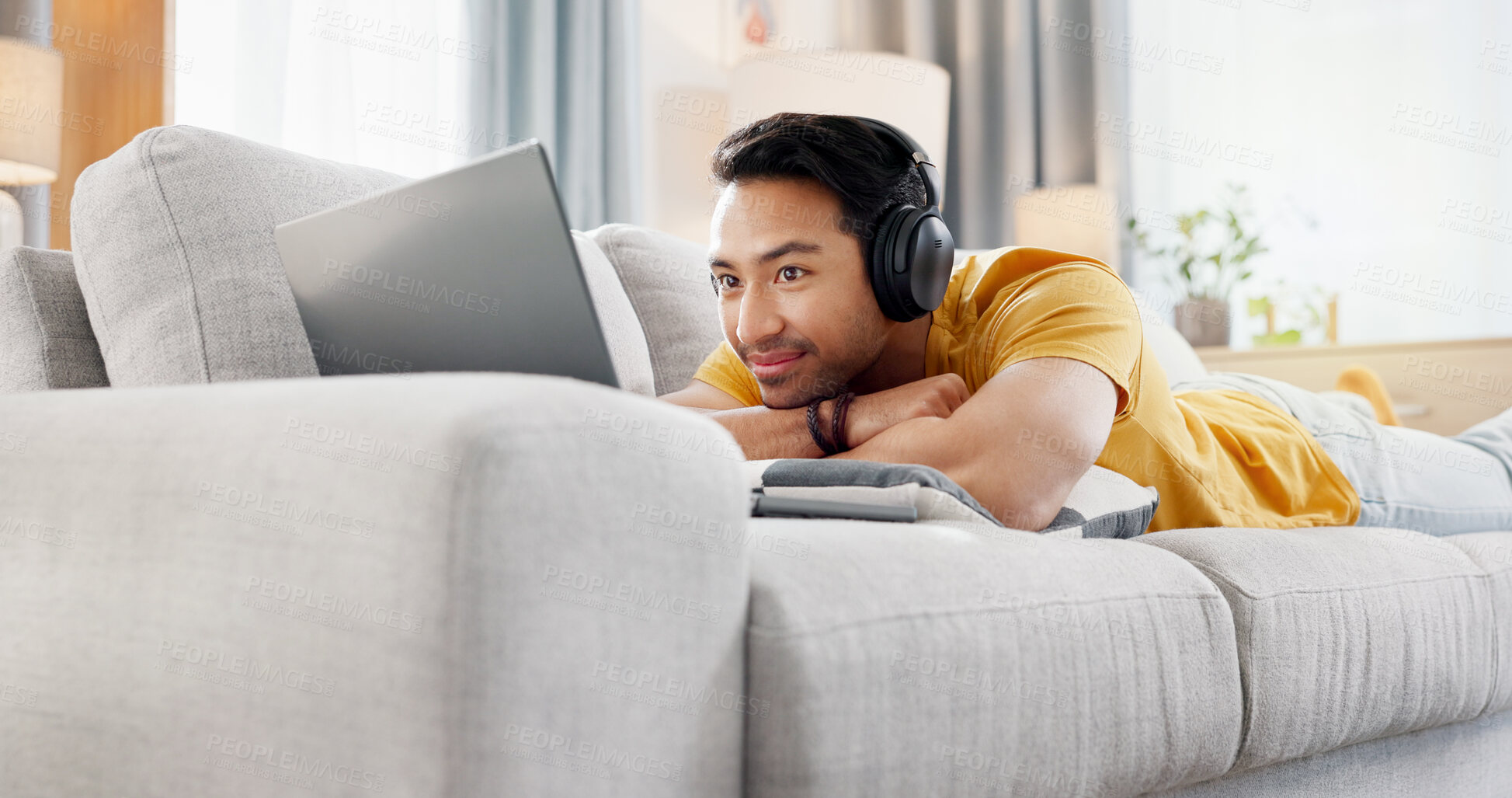 Buy stock photo Relax, laptop and movie with man on sofa for streaming service, headphones and film. Digital subscription, media website and home cinema app with person in living room of apartment for online video