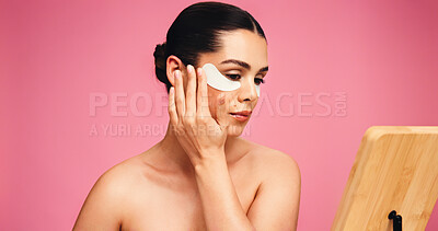 Buy stock photo Woman, mirror and eye mask for beauty in studio for dark circle, reduce puffiness and hydration. Person, cosmetic patches and mockup space for skincare, collagen benefits and shine on pink background