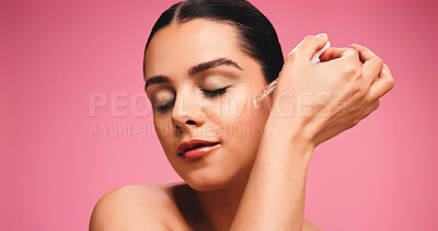 Buy stock photo Woman, dropper and oil for skincare in studio with space, application and beauty on pink background. Girl, model and cosmetics product for benefits with hyaluronic acid, collagen and dermatology
