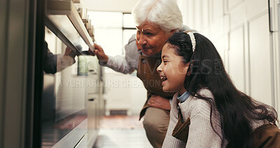 Buy stock photo Baking, excited and grandmother with girl by oven to check cookies, biscuits and cake in kitchen. Family, happy and senior woman with child in home for bonding, waiting and learning recipe together
