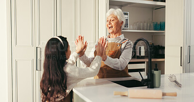 Buy stock photo Happy grandma, grandchild and high five in kitchen for baking success or dessert recipe in home. Senior woman, girl and smile with help, support or apron for fun cooking, bonding or learning together