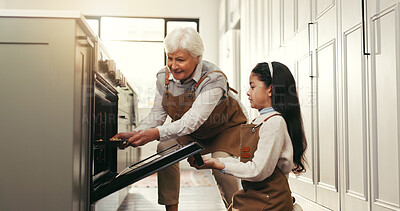 Buy stock photo Baking, kitchen and grandmother with girl by oven to check cookies, biscuits and cake on weekend. Family, happy and senior woman with child in home for bonding, helping and learning recipe together