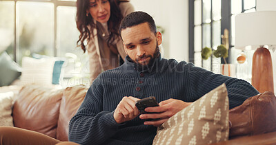 Buy stock photo Phone, relax and social media with man on sofa in living room of home for internet browsing. App, frustration and text message with couple in apartment for distraction, ignore or silent treatment