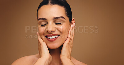 Buy stock photo Happy, makeup and touch face of woman on brown background for cosmetics and coverage. Skin glow, foundation and confidence of model in studio with mockup, space and self care for facial results