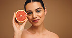 Happy, woman and grapefruit with portrait for skincare, natural beauty and facial glow. Smile, person and fruit for collagen, vitamin c and organic ingredients of treatment shine in studio background