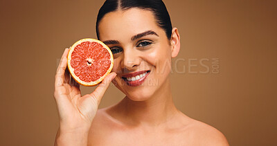 Buy stock photo Portrait, woman and grapefruit with smile for beauty, natural skincare and facial glow. Happy, person and fruit for collagen, vitamin c and organic ingredients of treatment shine in studio background