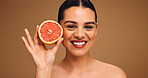Happy woman, portrait or skincare with grapefruit for diet or nutrition on a studio background. Face, female person or model with smile or natural organic fruit for vitamin C or health detox on space