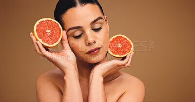 Buy stock photo Woman, beauty and grapefruit for natural skincare, organic cosmetics or vitamin C with self care in studio. Person, dermatology or fruit for healthy skin, mockup space or wellness on brown background