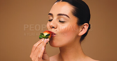 Buy stock photo Woman, eating or skincare with strawberry for diet, nutrition or health on a studio background. Female person, model or bite with natural organic fruit for wellness, vitamins or detox on mockup space