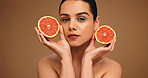 Woman, portrait and grapefruit with beauty for natural skincare, organic cosmetics or vitamin C in studio. Female person, dermatology and fruit for healthy skin, self care and wellness on background