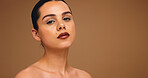 Dermatology, thinking or woman with makeup in studio, spa treatment or self care for glowing skin. Skincare, portrait or person with mockup space, grooming routine or cosmetics on brown background