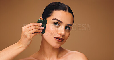 Buy stock photo Woman, gua sha and skincare in studio for beauty, lymphatic drainage or antiaging facial massage. Mockup space, person and jade stone for dermatology, natural cosmetic care and wellness on background