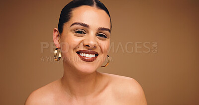 Buy stock photo Makeup, earrings and happy woman in studio for beauty, skin glow and brown background space. Aesthetic, ear jewelry and model with lipstick cosmetics, face transformation and portrait with change