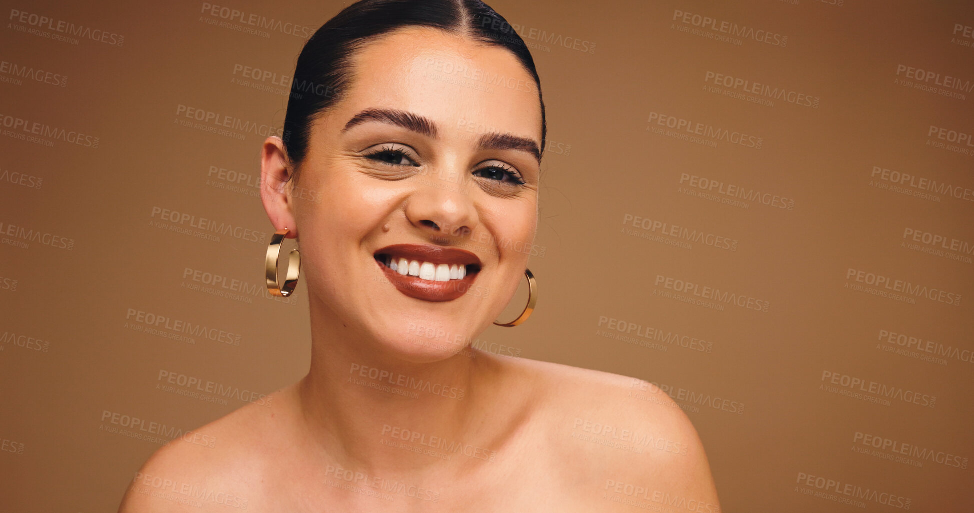Buy stock photo Makeup, earrings and happy woman in studio for beauty, skin glow and brown background space. Aesthetic, ear jewelry and model with lipstick cosmetics, face transformation and portrait with change