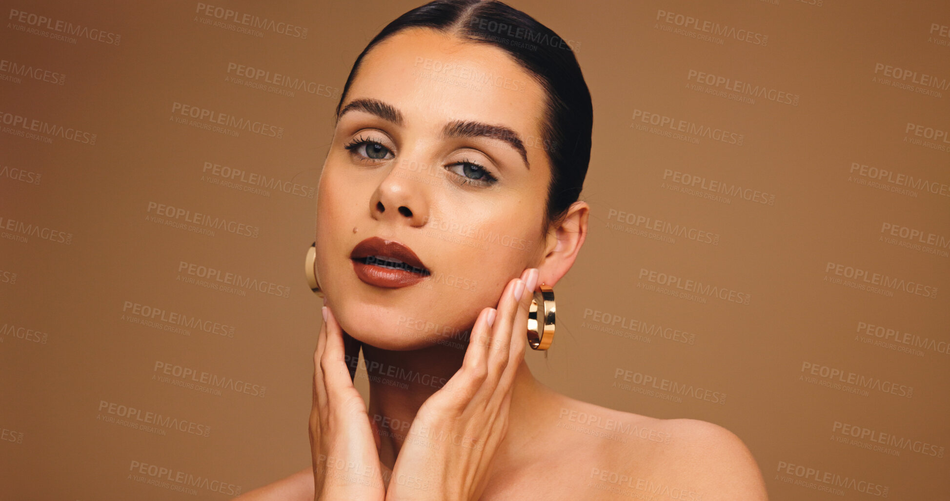 Buy stock photo Portrait, beauty and woman with makeup in studio for aesthetic, glow and space on brown background. Earrings, skin wellness and model with lipstick cosmetics, face transformation and confidence