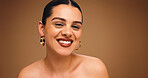 Portrait, beauty and happy woman with makeup in studio for aesthetic, glow or brown background. Earrings, skin wellness and model with lipstick cosmetics, face transformation or confidence with space