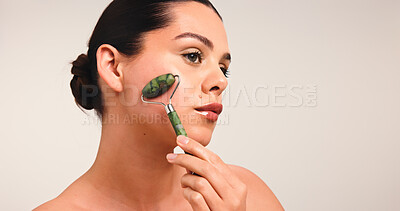 Buy stock photo Skincare, beauty and woman with jade roller in studio with natural, cosmetic and glow. Health, mockup space and female person with face tool for dermatology routine for wellness by white background