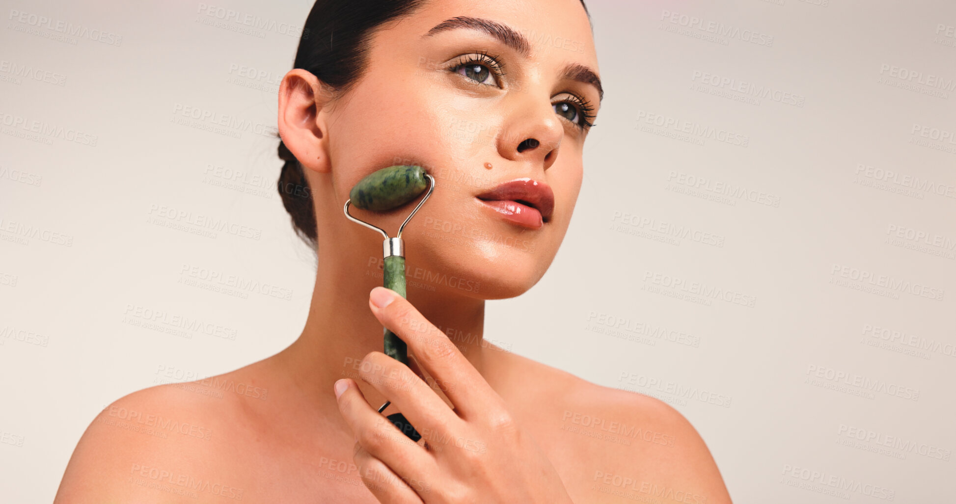 Buy stock photo Skincare, glow and woman with facial roller in studio with natural, cosmetic and beauty. Health, mockup space and female person with face tool for dermatology routine for wellness by white background