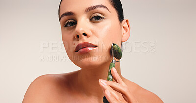Buy stock photo Woman, portrait or skincare with jade roller in studio for facial massage on a white background. Female person, model or treatment with beauty tool for lymphatic drainage, health or wellness on space