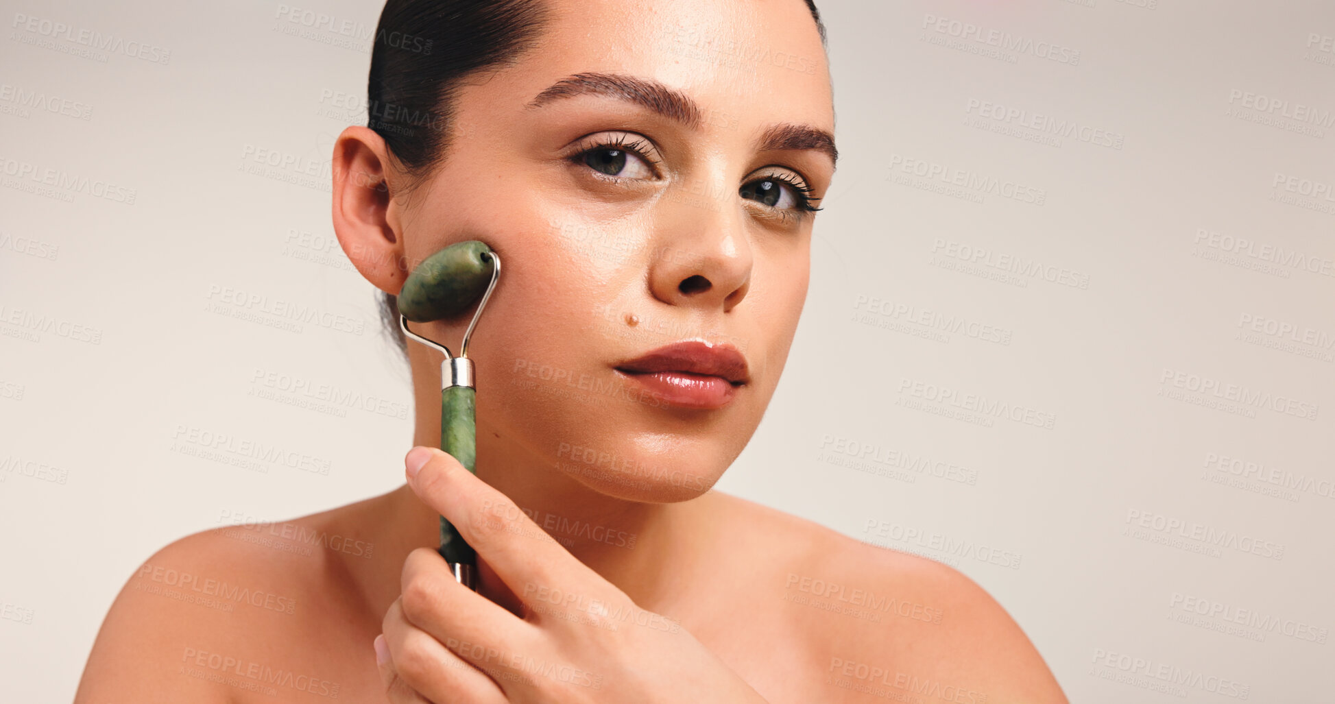 Buy stock photo Woman, portrait or beauty with jade roller in studio for facial massage on a white background. Female person, model or treatment with skincare tool for lymphatic drainage, health or wellness on space