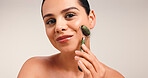 Happy woman, portrait or jade roller in studio for facial treatment on a white background. Female person, model face or skincare with beauty tool for lymphatic drainage, health and wellness on space