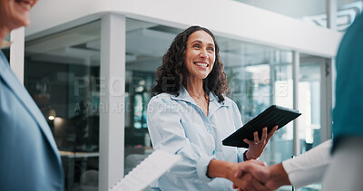 Buy stock photo Handshake, doctor and woman in hospital, tablet and welcome with smile, thank you and hello. Mature person, healthcare and happy employees in workplace, shaking hands and tech with onboarding or app