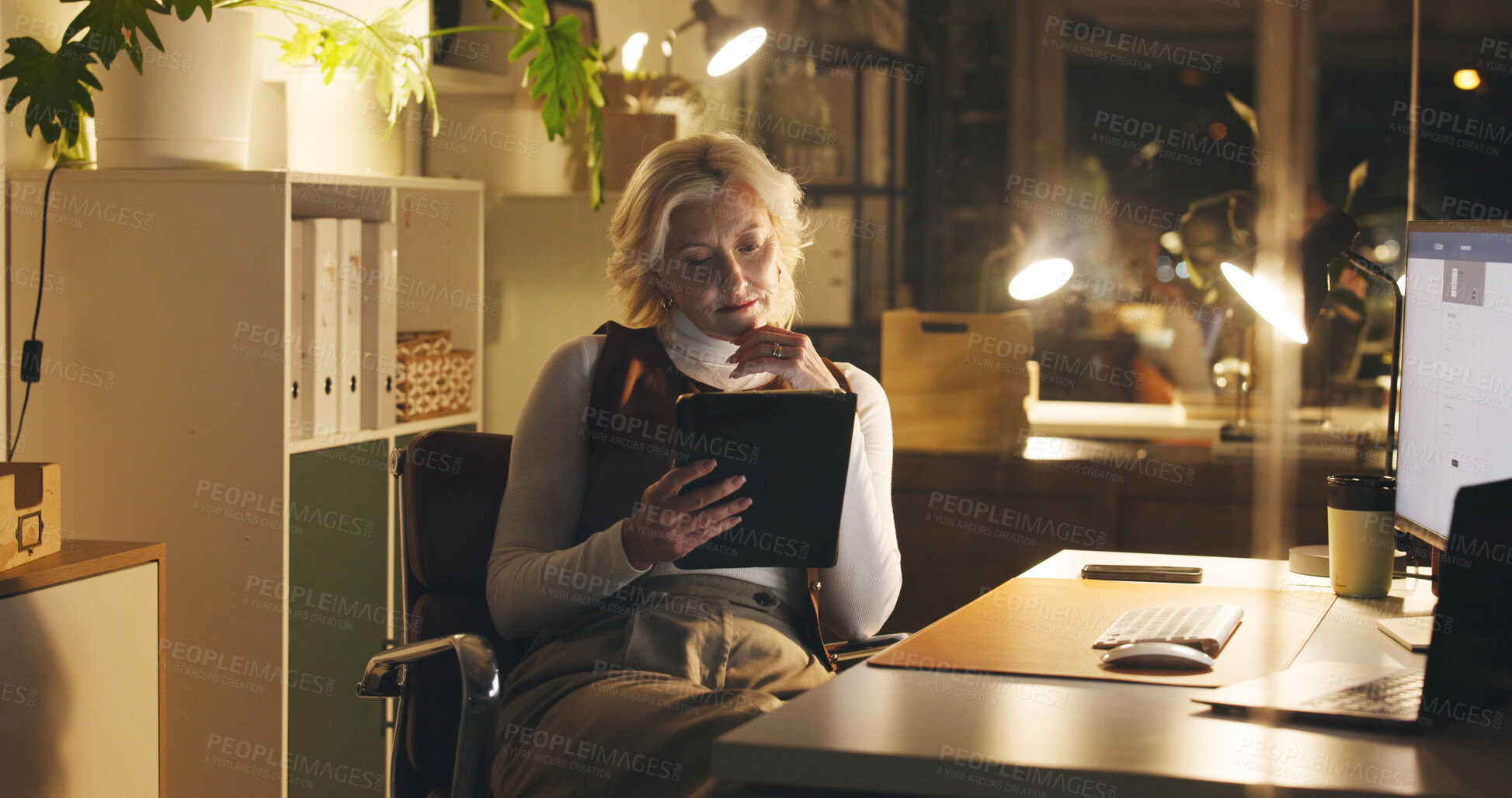Buy stock photo Tablet, reading and mature businesswoman in office at night for creative project with deadline. Communication, email and professional editor with contact for article for publishing in workplace.