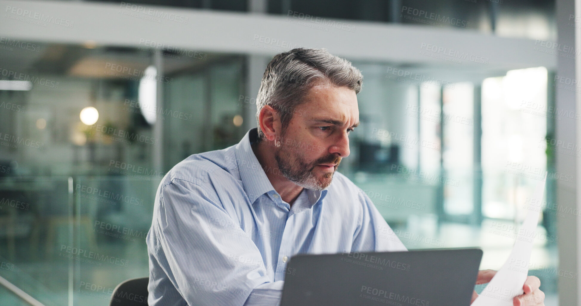 Buy stock photo Reading, business man and paperwork with laptop for investment report, stocks evaluation or IPS. Portfolio manager, mature person and serious with document in office for economic data or performance