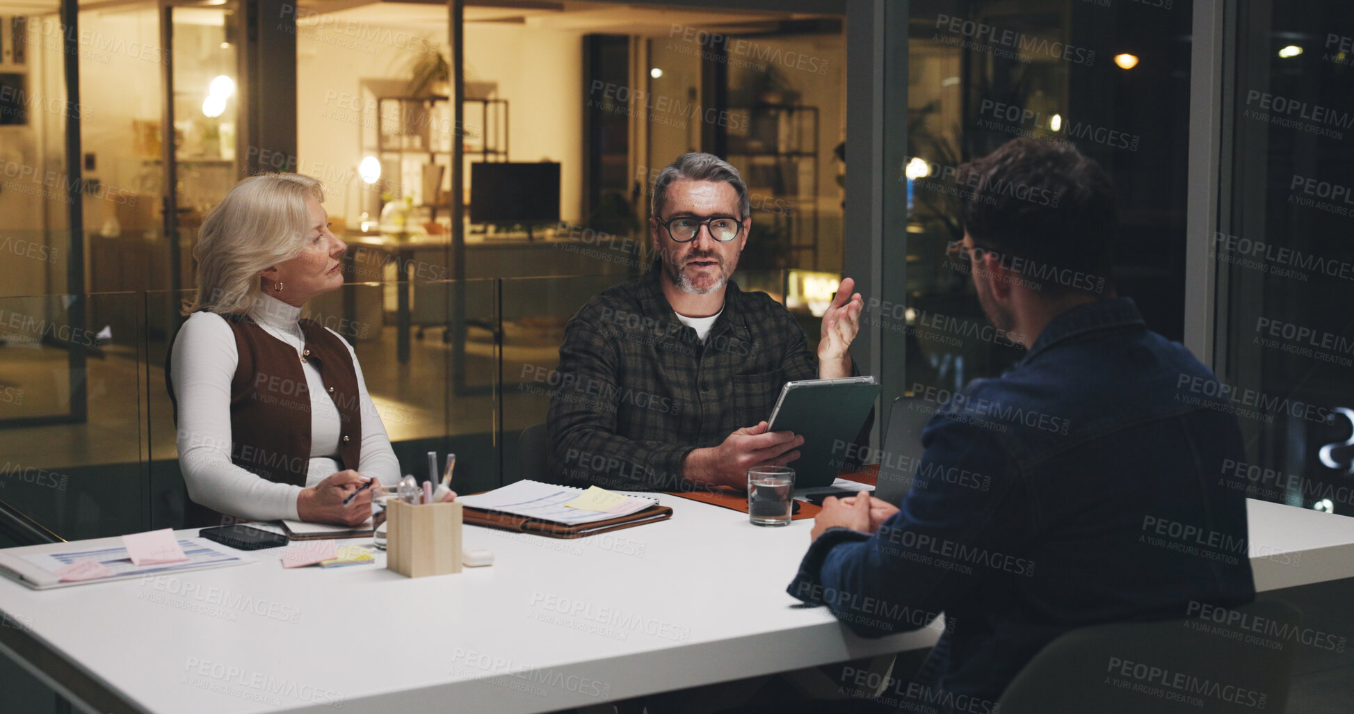 Buy stock photo Business, team and tablet in meeting at night for editorial planning, article ideas and feedback. Publishing agency, people and editor with discussion for story guidance, topics review and deadline