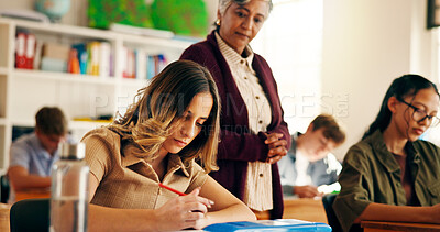 Buy stock photo Teacher, student and writing notes in classroom for education, lesson revision and quiz. Girl, teenager and learning for high school assignment, study process and information for academic curriculum