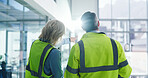 Back, people and engineering with discussion at construction site, building inspection and teamwork. Architecture, civil engineer collaboration and man with woman pointing for real estate development