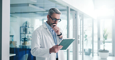 Buy stock photo Reading, tablet and thinking with doctor in hospital for healthcare report, research grant and reflection. Medical case idea, clinical guidelines and telehealth app with mature person for vision